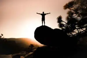 Mann auf Felsen bei Sonnenuntergang